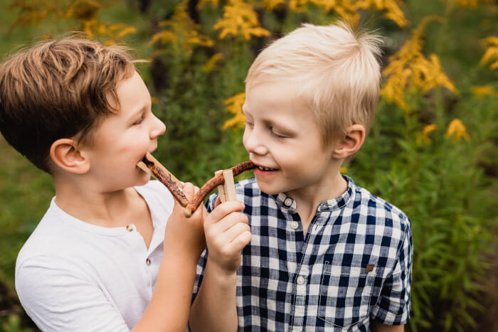 Zwei Jungen nebeneinander. In der Hand haben beide eine Klammerwurst an der Holzklammer.