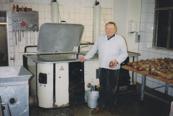 Gerhard Fessel in der Fleischerei. Neben ihm viele Produkte.
