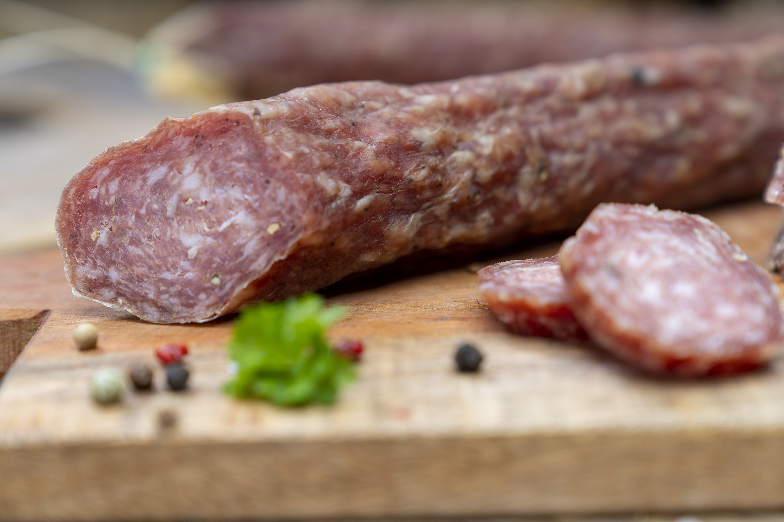 Angeschnittene Eichsfelder Stracke. Daneben Kräuter und ein paar Scheiben der Wurst.