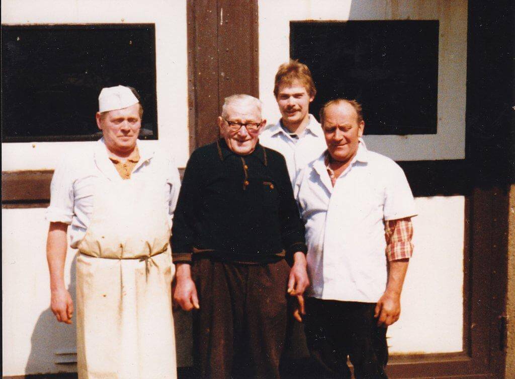 Gerhard, Karl und Erwin Fessel stehen vor der Fleischerei.